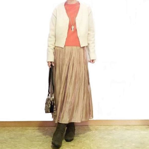 アーモンドプードル色のショートカーディガンに光沢プリーツスカートを合わせた大人可愛い冬コーデ
