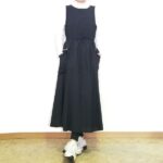 黒の撥水ジャンパースカートに白のハイネックインナーとレギンス、スニーカーを合わせた冬から春へのカジュアルコーデ。